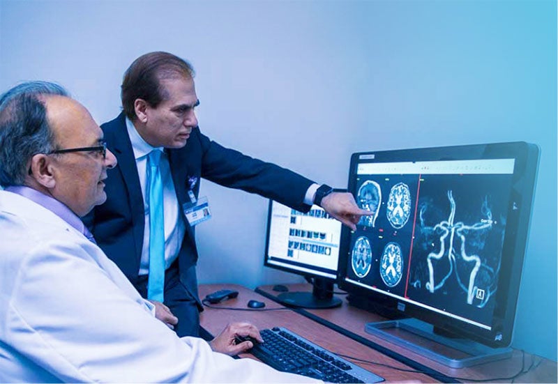 Two healthcare professionals analyzing a patient scan